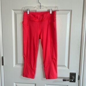 Neon red leggings with pockets and cutout calf detail.
